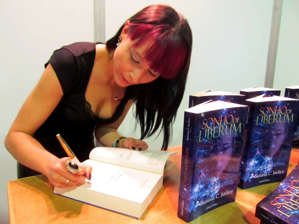 Mulher a autografar livros Sonho Liberum numa mesa