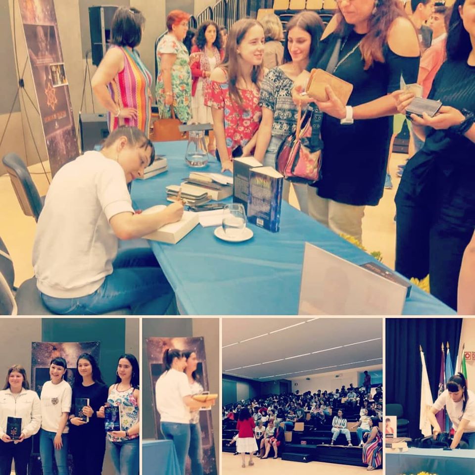 Evento de autógrafos com homem a assinar livros e fila de pessoas numa sala de conferências