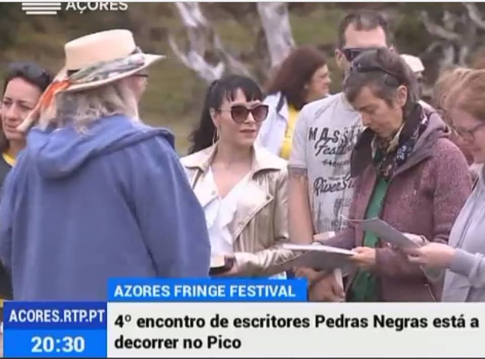 Pessoas a ler papéis ao ar livre com árvores ao fundo