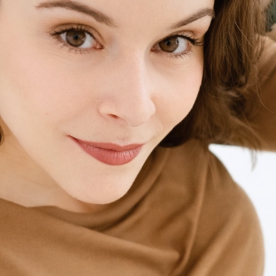 Brincos dourados com detalhe transparente em mulher de camisola castanha