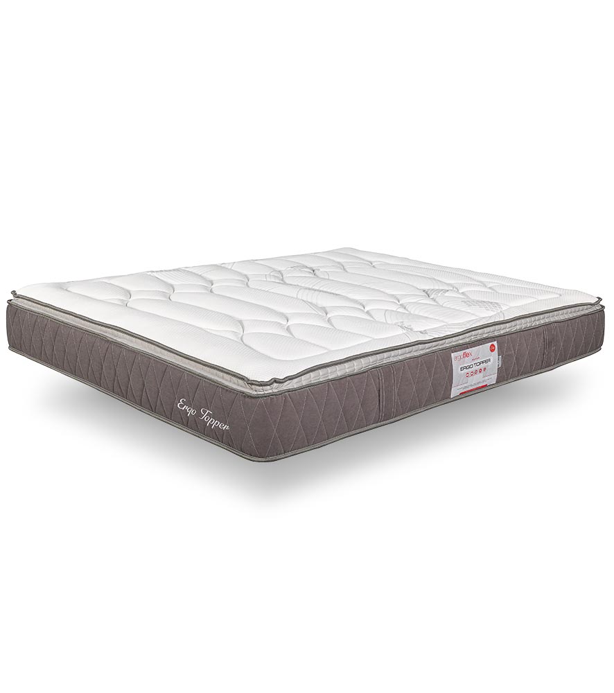 Colchão branco e cinza com etiqueta e nome bordado numa superfície branca.