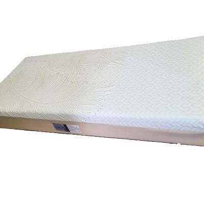 Colchão branco retangular com padrão texturizado e etiqueta na lateral