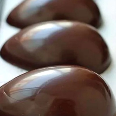 Três doces de chocolate redondos brilhantes em linha