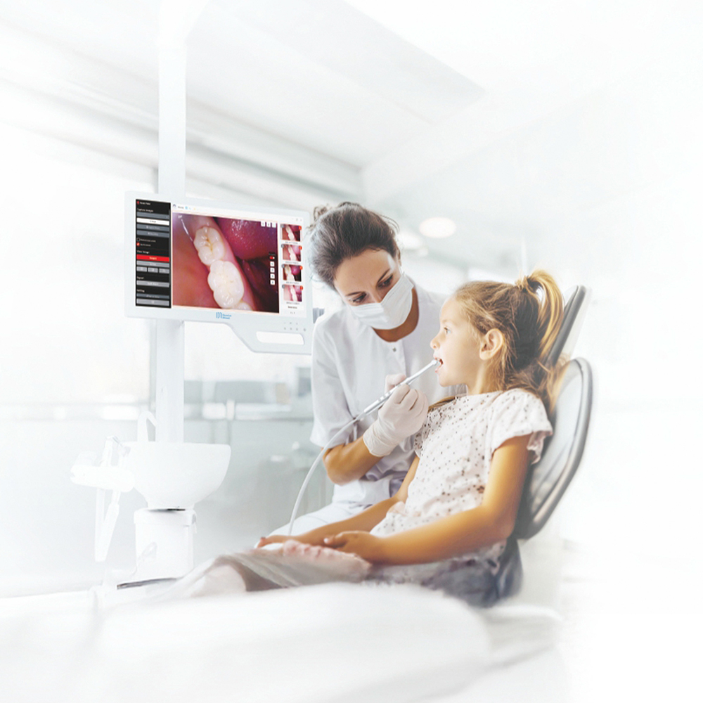Câmera intraoral DM Cam | DentsMind Dentista examinando menina numa cadeira dentária com imagem ampliada de dentes no monitor