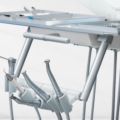 Equipamento dentário com instrumentos pendurados num suporte branco