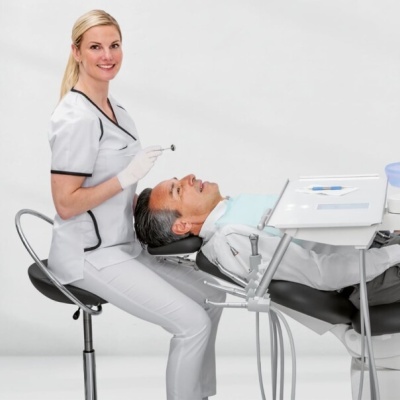 Dentista com paciente numa cadeira dentária, fundo branco