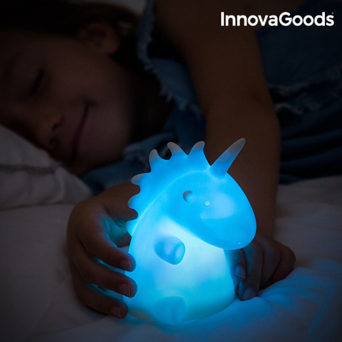 Candeeiro Unicórnio Multicolor LEDicorn InnovaGoods Candeeiro de unicórnio azul fosco luminoso nas mãos de uma criança deitada