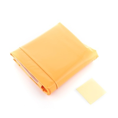 Lençol amarelo claro dobrado com pequeno pano amarelo ao lado