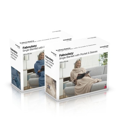 Embalagens da manta Faboluazy com mangas e bolso, uma em bege outra azul, com modelos sentados no sofá.