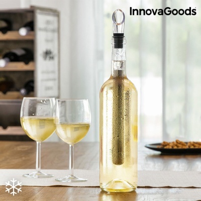 Garrafa com enfriador metálico e duas taças de vinho branco numa mesa
