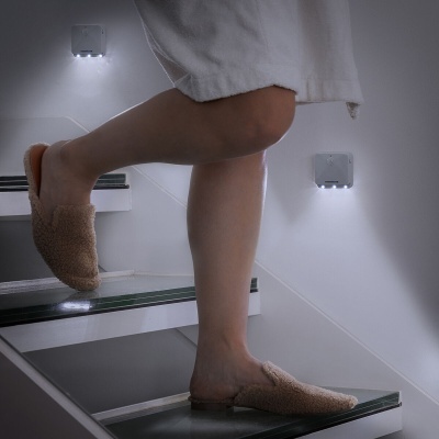 Pantufas castanhas de pelo macio em escadas interiores com iluminação LED