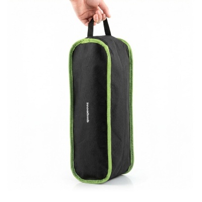 Bolsa preta com bordas verdes e alça preta, com texto InnovaGoods, segurada por uma mão