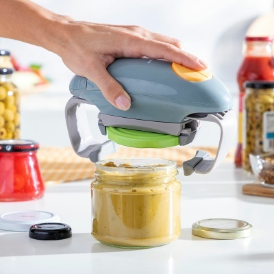 Abridor elétrico de frascos azul e cinza com botão amarelo a abrir frasco de vidro