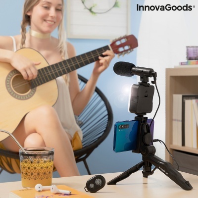 Tripé de mesa com suporte para smartphone e microfone ao lado de mulher a tocar guitarra