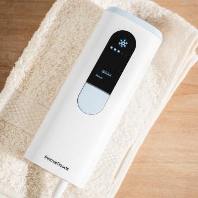 Dispositivo branco InnovaGoods com visor digital preto sobre toalhas brancas