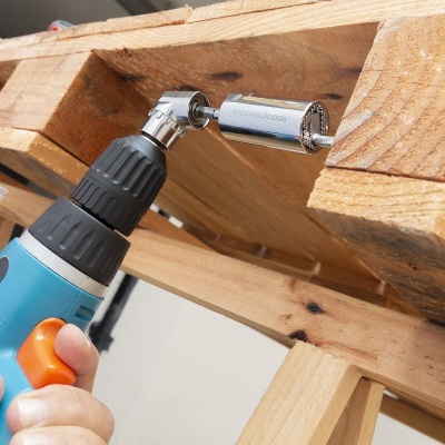 Ferramenta elétrica azul e preta com extensão metálica a apertar parafuso em madeira