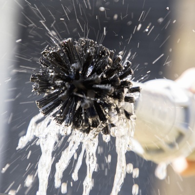 Escova redonda preta com água a escorrer