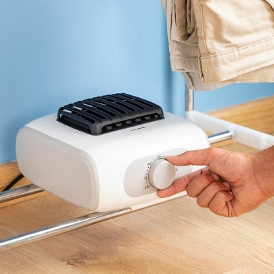 Aparelho branco compacto com botão de controlo num varão metálico