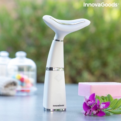 Dispositivo branco InnovaGoods com detalhes prateados sobre mesa com flores roxas