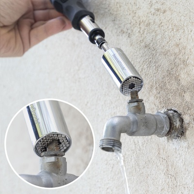 Torneira metálica com dispositivo cilíndrico prateado acoplado e água a sair