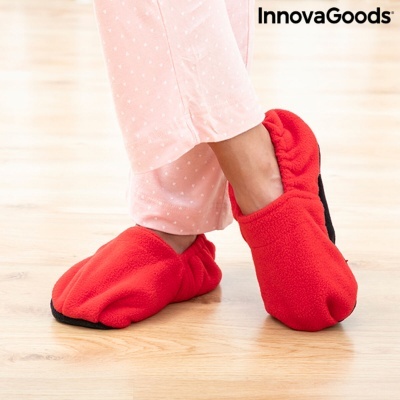 Pantufas vermelhas confortáveis usadas em piso de madeira claro