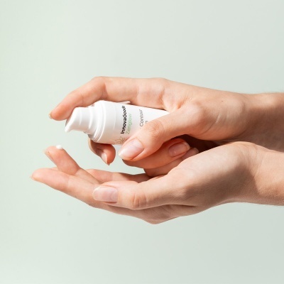Frasco branco pump de creme Innovacosmet Contour nas mãos
