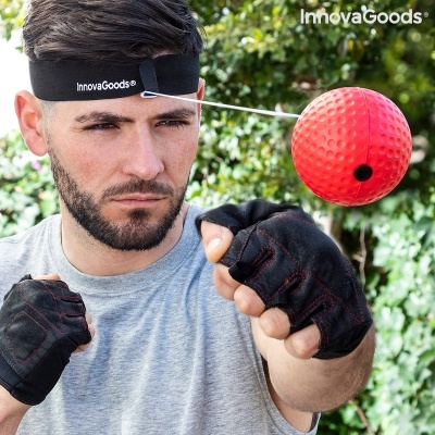 Homem em treino de boxe com equipamento de bola presa à cabeça, faixa preta com texto InnovaGoods e luvas pretas