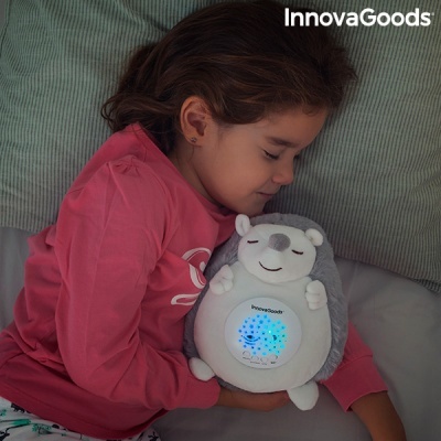 Menina a dormir abraçada a peluche porco-espinho luminosa InnovaGoods
