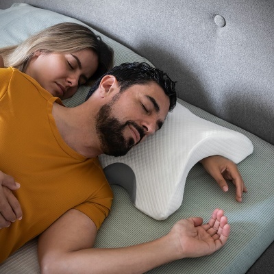 Travesseiro ergonómico branco em cama com homem e mulher adormecidos