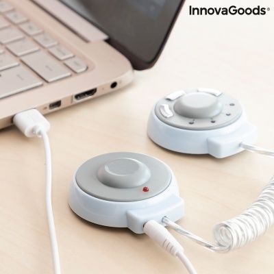 Controlador de volume circular prateado e branco junto a portátil bege-rosado