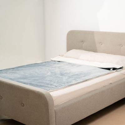 Cama de casal estofada cinzenta com colcha cinzenta clara e lençol branco