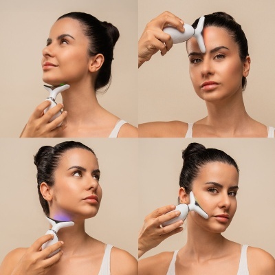 Mulher a usar dispositivo de tratamento facial LED branco na cara com fundo bege.