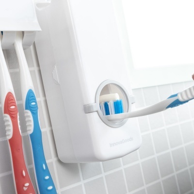 Dispenser branco de pasta dentífrica com escova azul inserida na parede
