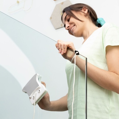 Mulher a segurar bastão de pesca com carreto branco em ambiente interior