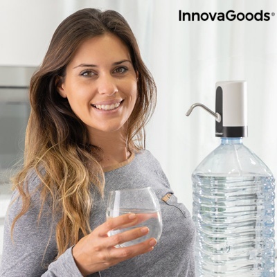 Mulher sorridente com copo de água e garrafa grande com dispensador numa cozinha