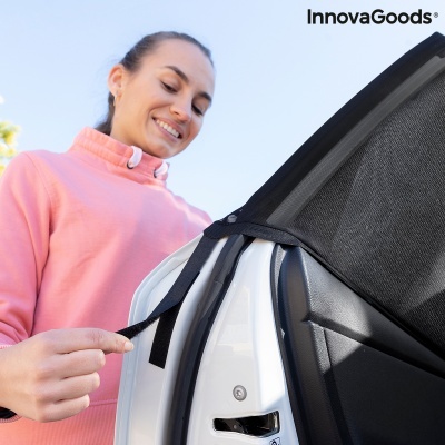 Mulher a prender uma cobertura preta de tecido na porta de um carro branco com céu azul ao fundo