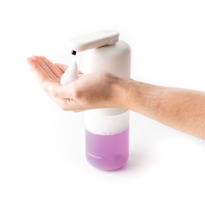 Dispenser automático de espuma com líquido roxo e espuma branca na mão