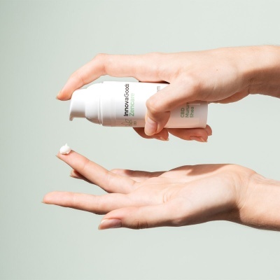 Dispenser branco de creme InnovaGood CBD a ser aplicado nas mãos