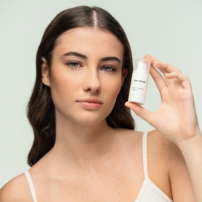 Mulher segura frasco branco pequeno com tampa translúcida