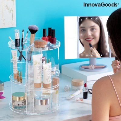 Organizador giratório transparente de maquilhagem com diversos cosméticos e espelho iluminado em fundo azul