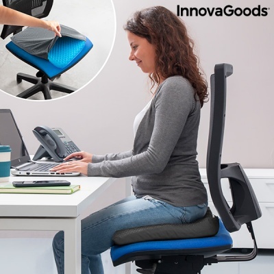 Almofada ergonómica de assento azul com capa cinzenta numa cadeira de escritório preta em ambiente de escritório com mesa branca e equipamentos