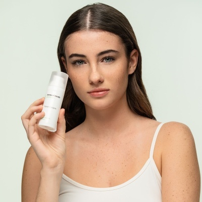 Mulher segurando embalagem branca de produto Magic Skin Co.