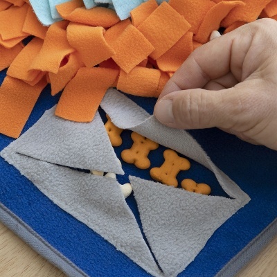 Tapete felpudo azul e cinzento com petiscos em forma de ossos escondidos