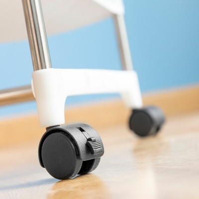 Rodas pretas com estrutura metálica e suporte branco sobre chão de madeira