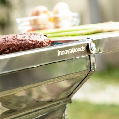 Grelhador inox InnovaGoods com hambúrguer, espargos e ovos em ambiente exterior