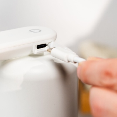 Dispositivo branco com porta USB tipo C sendo conectado por uma mão