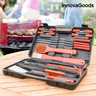 Conjunto de utensílios para churrasco InnovaGoods com cabos laranja e mala preta sobre mesa de madeira.