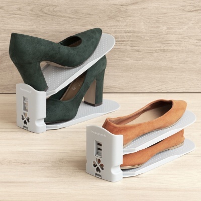 Organizador empilhador para calçado com sapatos verdes e castanhos em superfície de madeira