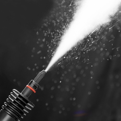 Aspersor de água preto com junta vermelha emitindo jato de água