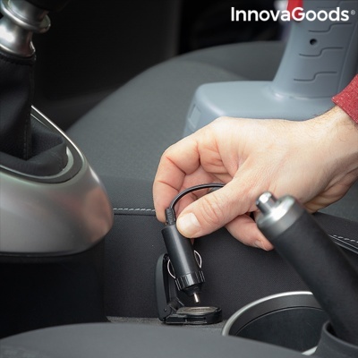 Carregador USB preto a ser inserido na tomada de isqueiro de um carro cinzento com texto InnovaGoods.